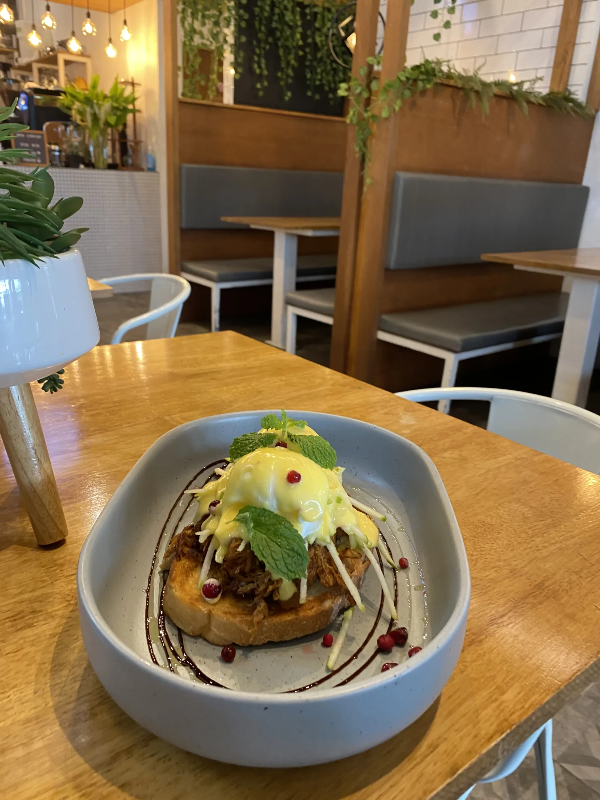 Eggs benedict topped with hollandaise sauce, mint and pomegranate seeds at the cafe that serves the best food in Chalong: Poached Breakfast Cafe, Chalong, Phuket, Thailand