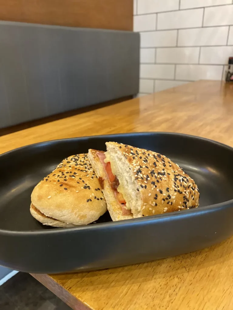 Ham, cheese, sundried tomato sandwich on a table at one of the best places to visit in Chalong, Poached Breakfast Cafe, Chalong, Phuket, Thailand