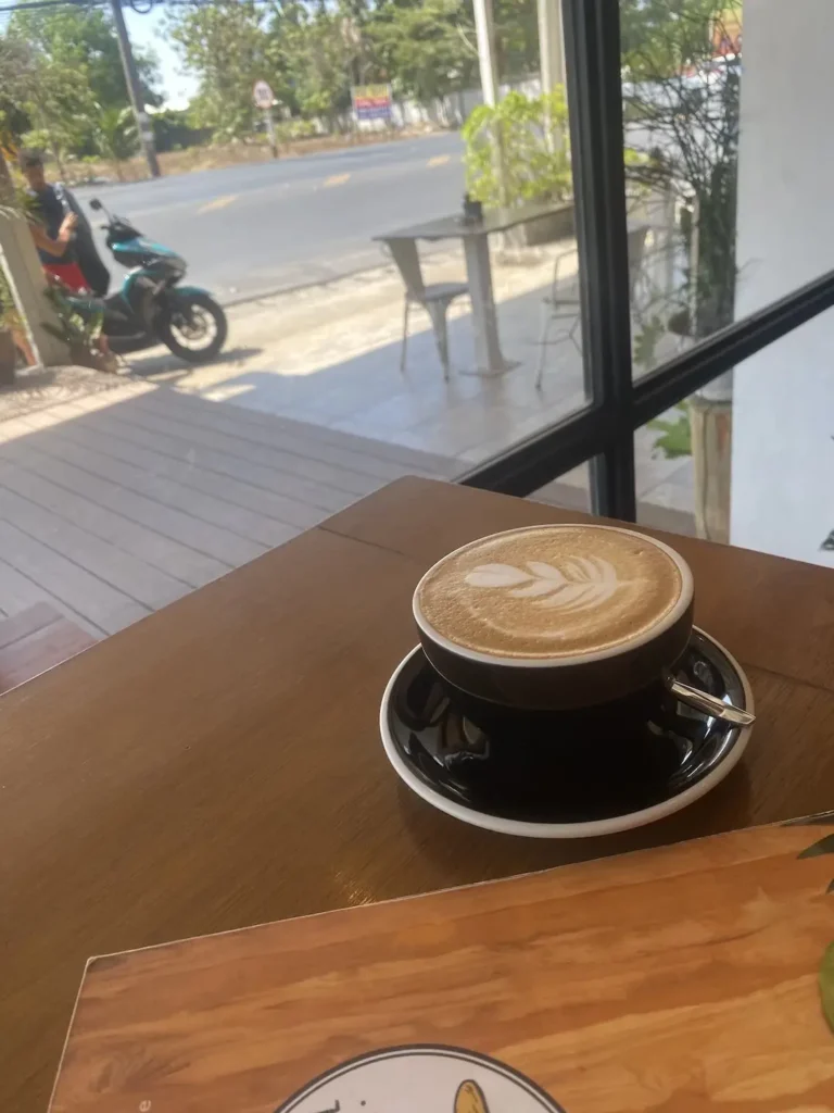 Latte with the menu in the sunshine. The perfect accompaniment best Chalong sandwich which can only be found at Poached Breakfast Cafe, Chalong, Phuket, Thailand