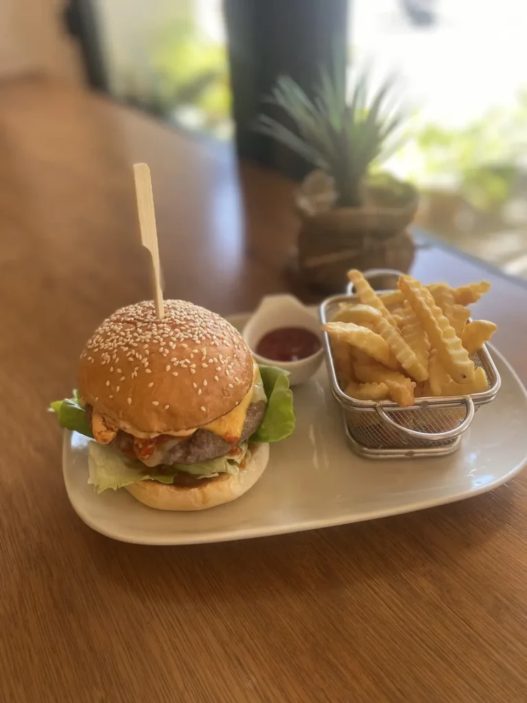 Spicy beef patty in a burger with fries and ketchup and an egg. The best Chalong sandwich which can only be found at Poached Breakfast Cafe, Chalong, Phuket, Thailand
